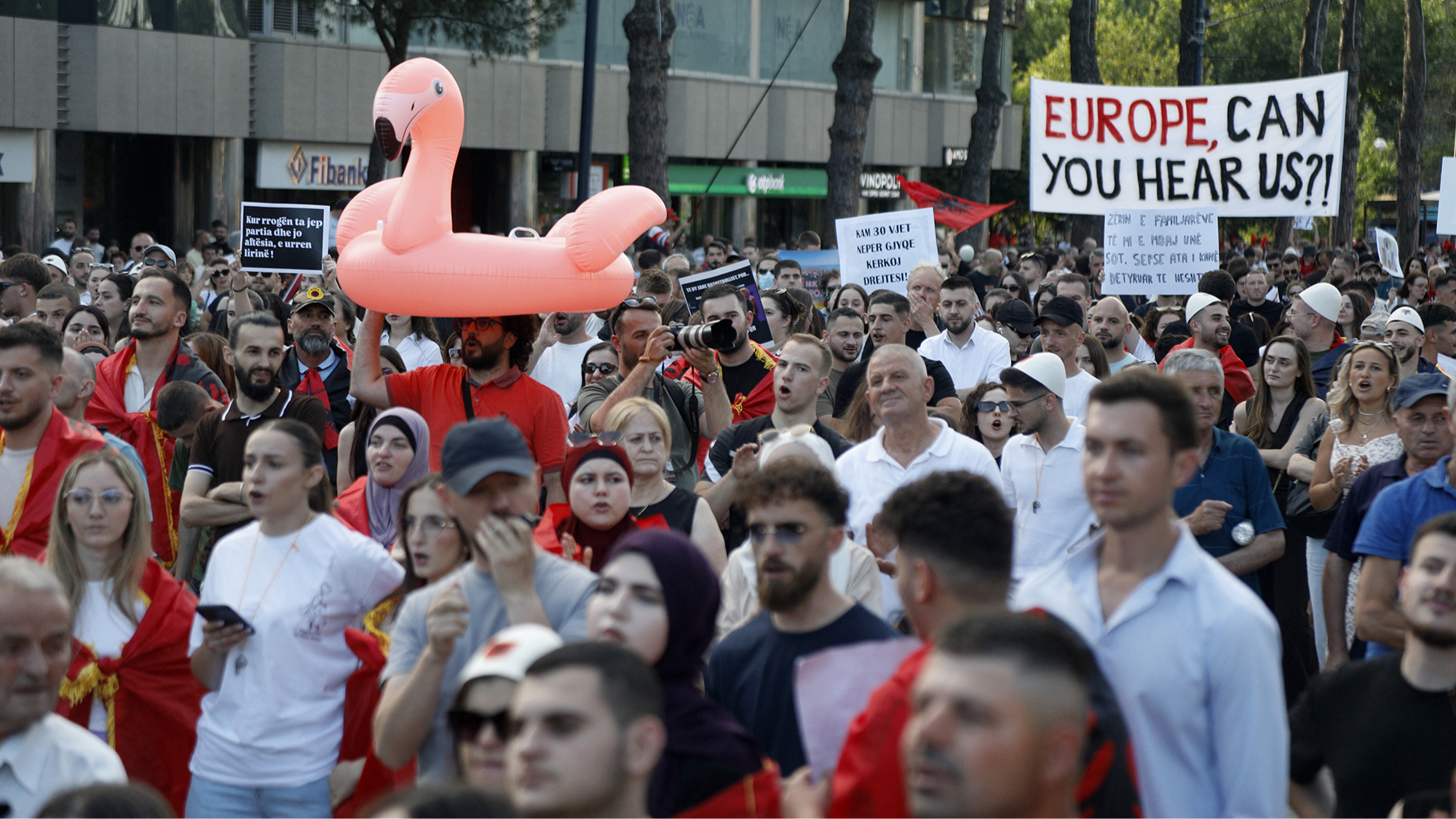 A protester holds an inflatable flamingo during a demonstration against the construction of a luxury resort near a protected natural area, as crowds gather in front of the Prime Minister’s office in Tirana, Albania  